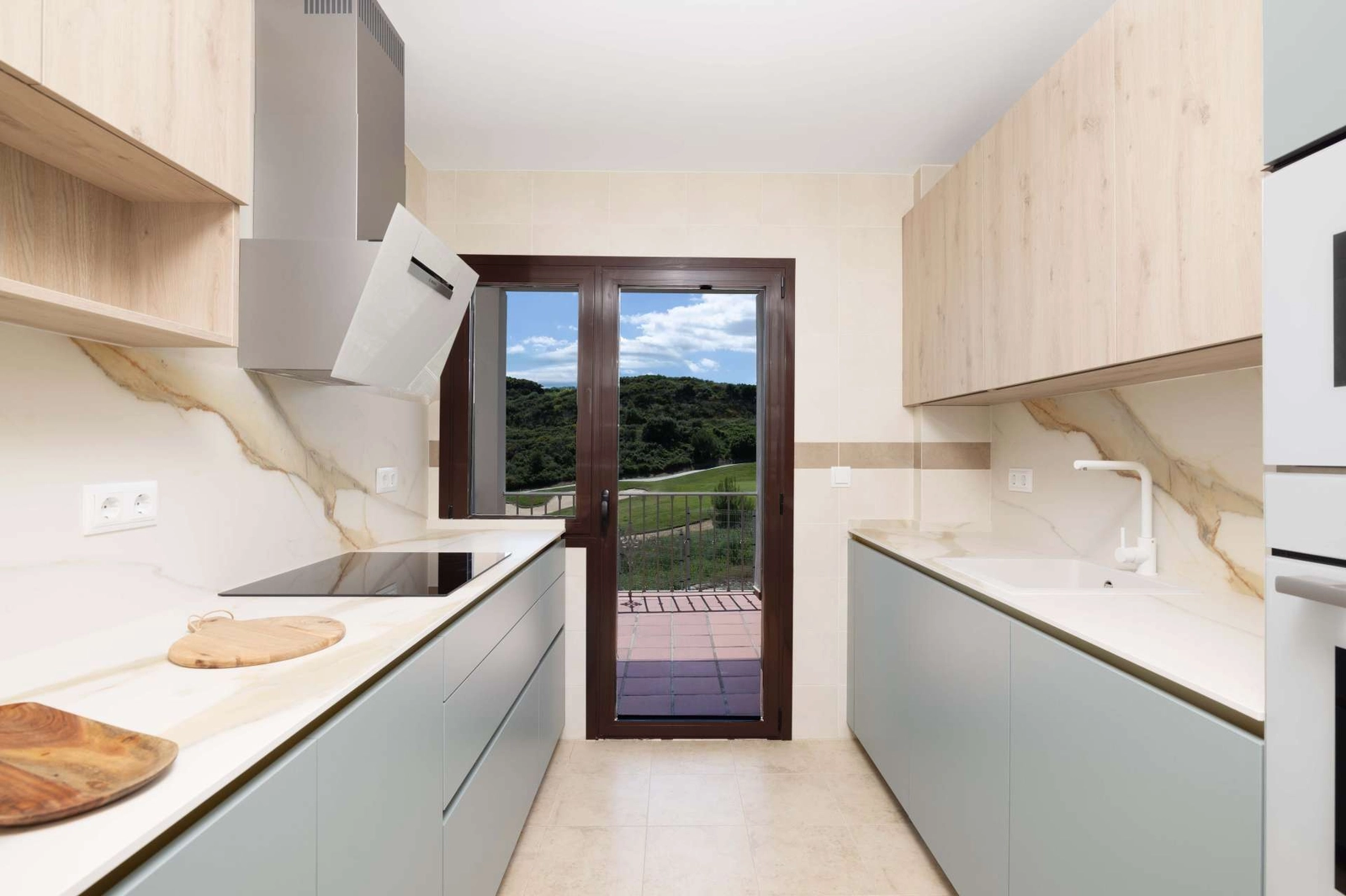 Det moderne køkken er designet med funktionalitet og stil for øje, med udsigt til det fri.