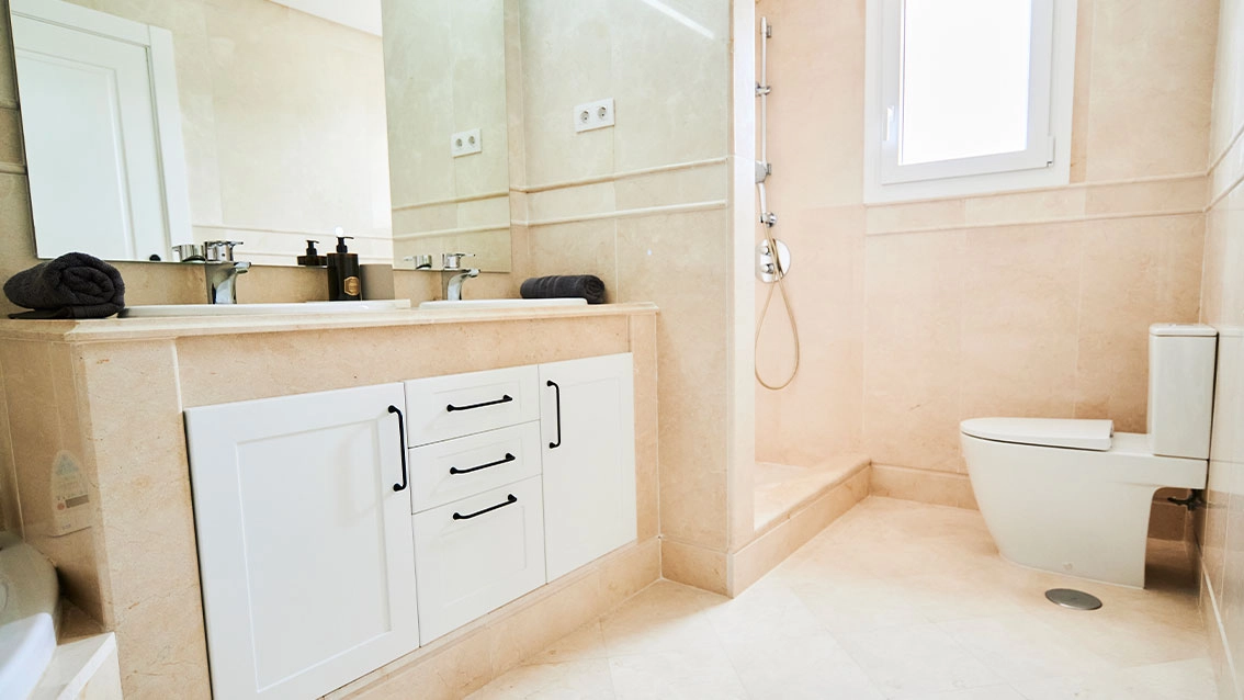 Et elegant badeværelse med materialer af høj kvalitet og moderne armaturer for en spa-lignende oplevelse derhjemme.