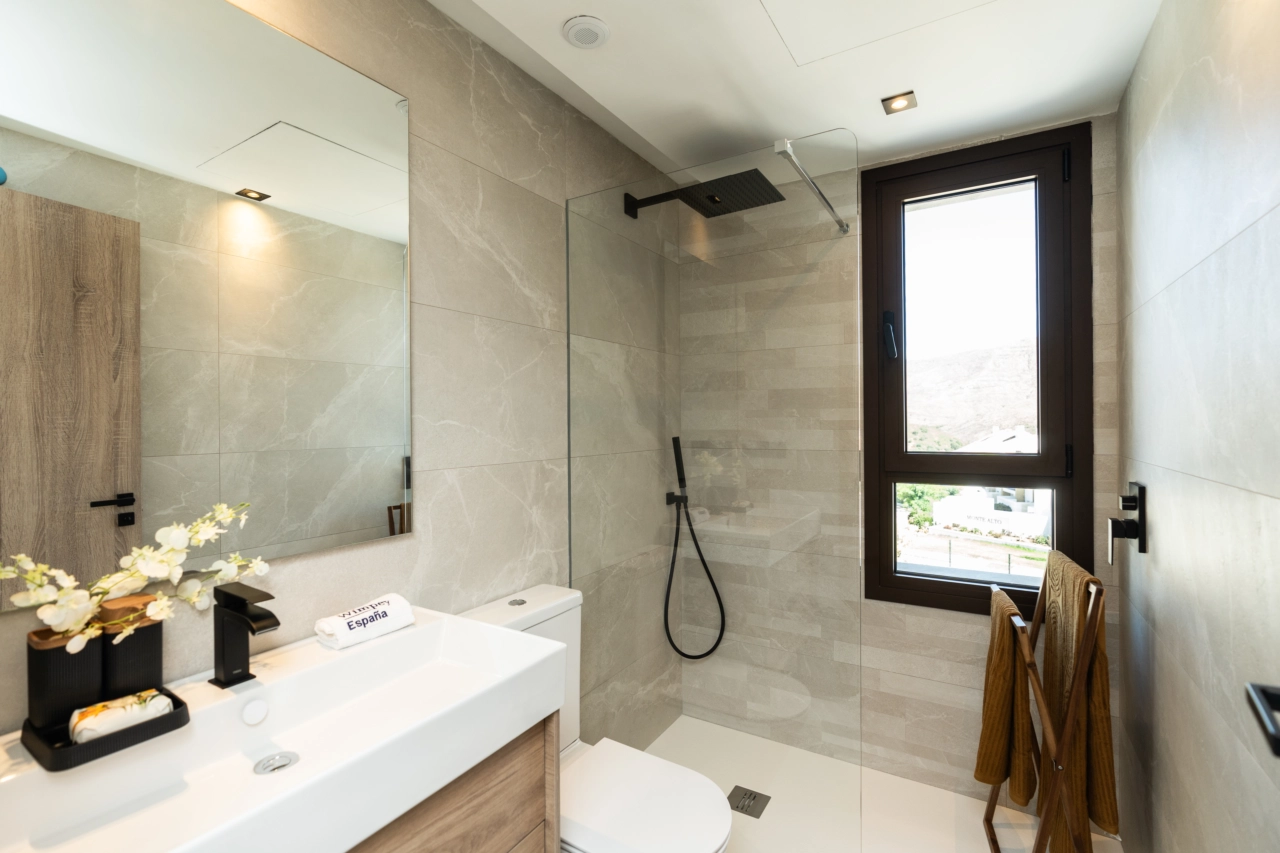 Et stilrent, moderne badeværelse med armaturer af høj kvalitet og walk-in bruser.