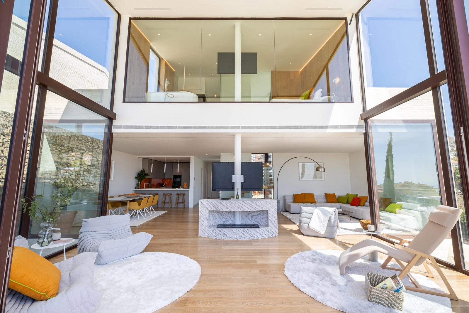 Et kig ind i det dobbelthøje opholdsrum, hvor arkitektur og natur føles forbundet.