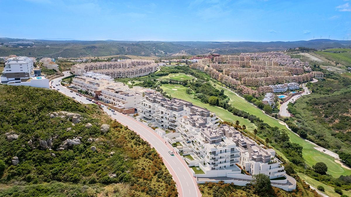 Et luftfoto af bebyggelsen, perfekt integreret i Costa del Sols frodige grønne landskab med nærliggende golfbaner.