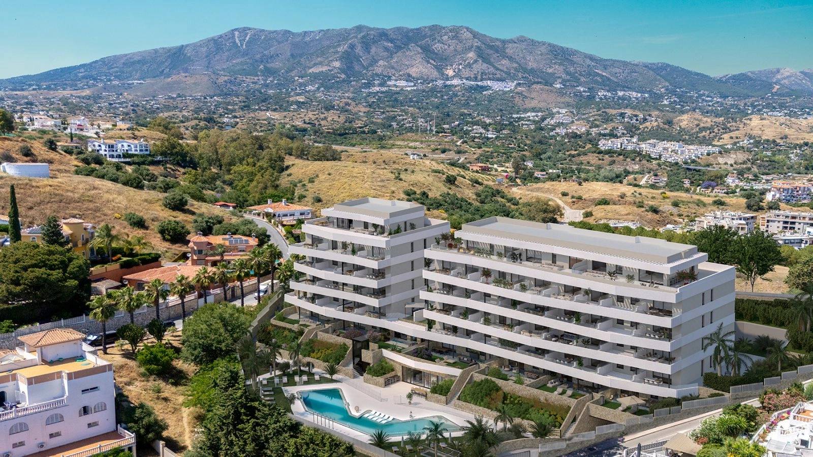 En luftfoto af bebyggelsen, beliggende i Mijas-bakkerne med bjergene som en fantastisk kulisse.