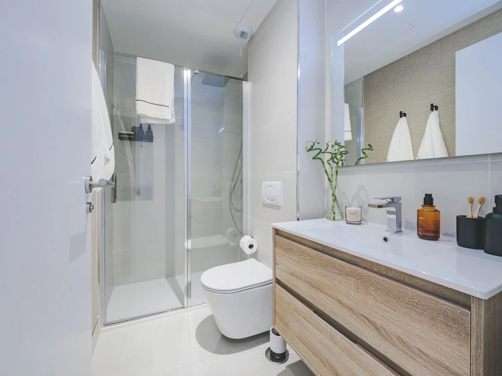 Et sekundært badeværelse, der udstråler moderne stil og funktionalitet med en rummelig walk-in bruser.