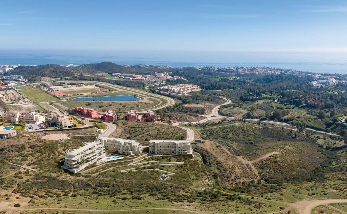 Et luftfoto, der viser bebyggelsens førsteklasses beliggenhed i Mijas, tæt på havet og lokale faciliteter.