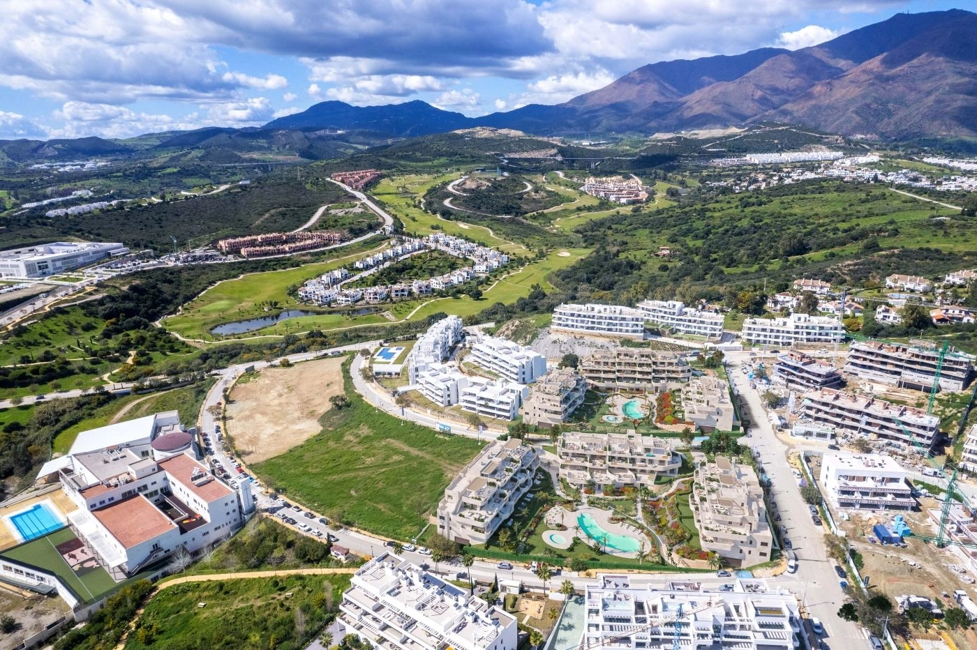 Byggeriet ligger i et grønt landskab med udsigt over de omkringliggende bakker og nærliggende golfbaner.
