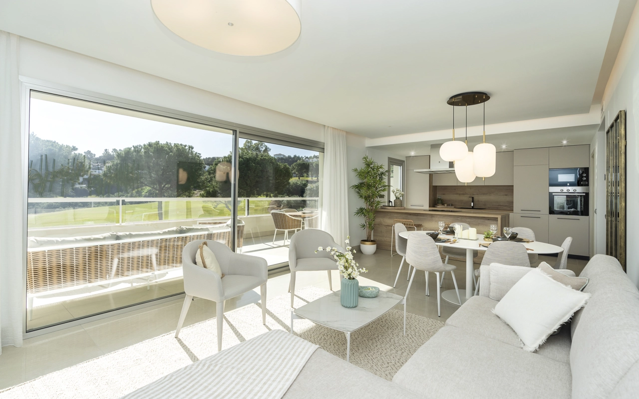 Solskin fylder det åbne stue- og spiseområde og skaber en lys og indbydende ramme for afslapning og underholdning.
