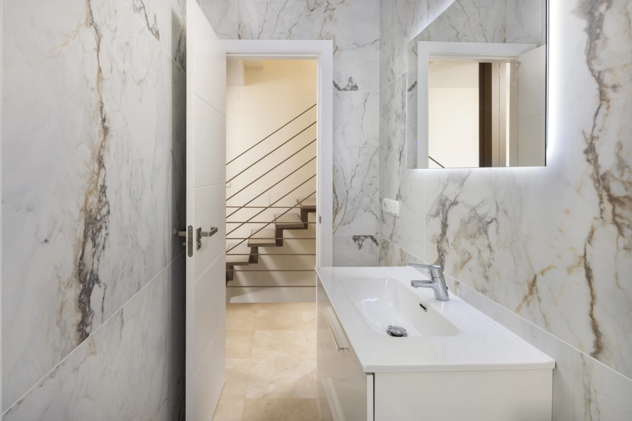 Et moderne gæstebadeværelse med stilfulde fliser og armaturer af høj kvalitet.