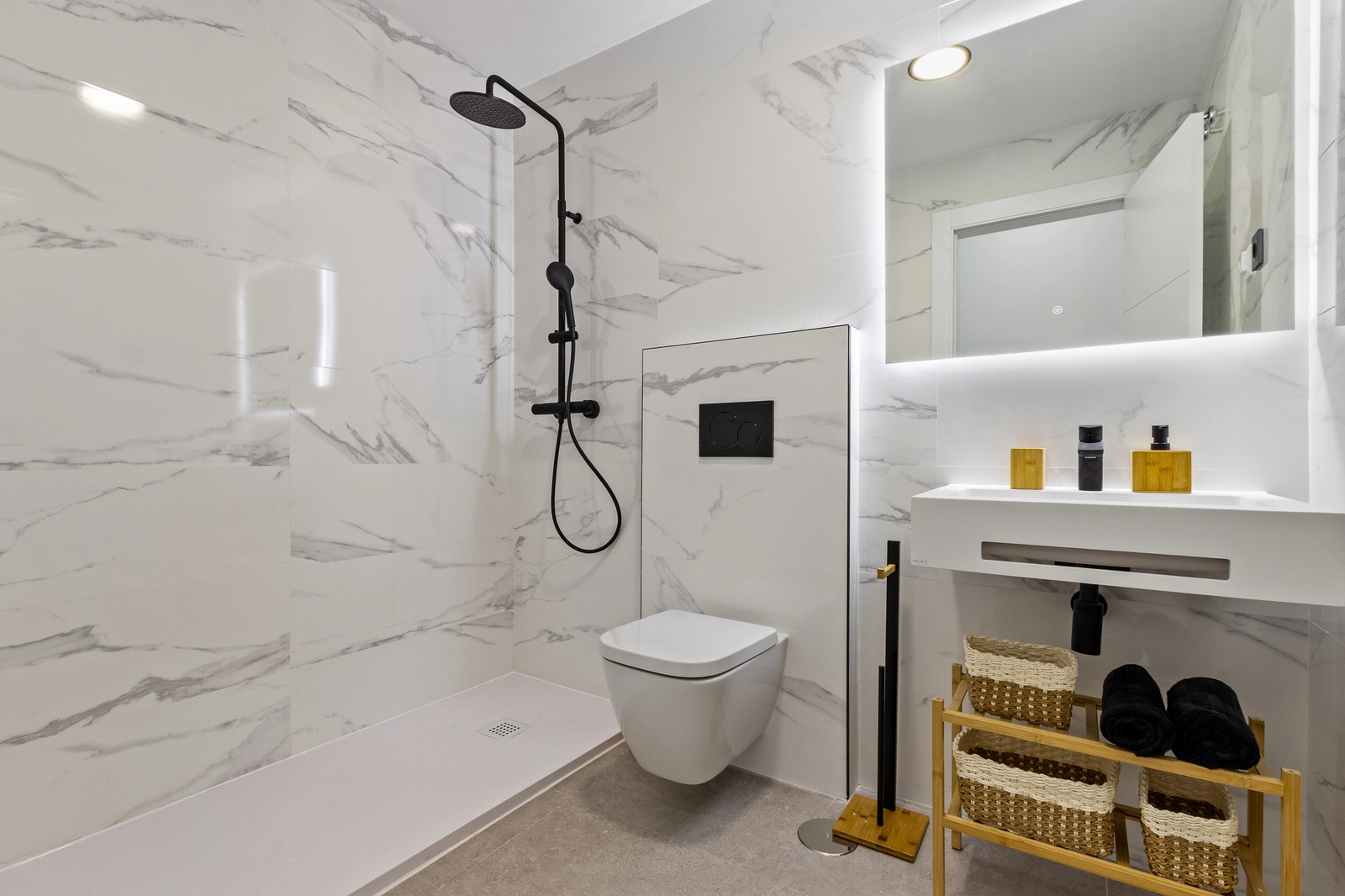 Et moderne badeværelse udført i materialer af høj kvalitet, med walk-in bruser og moderne armaturer.