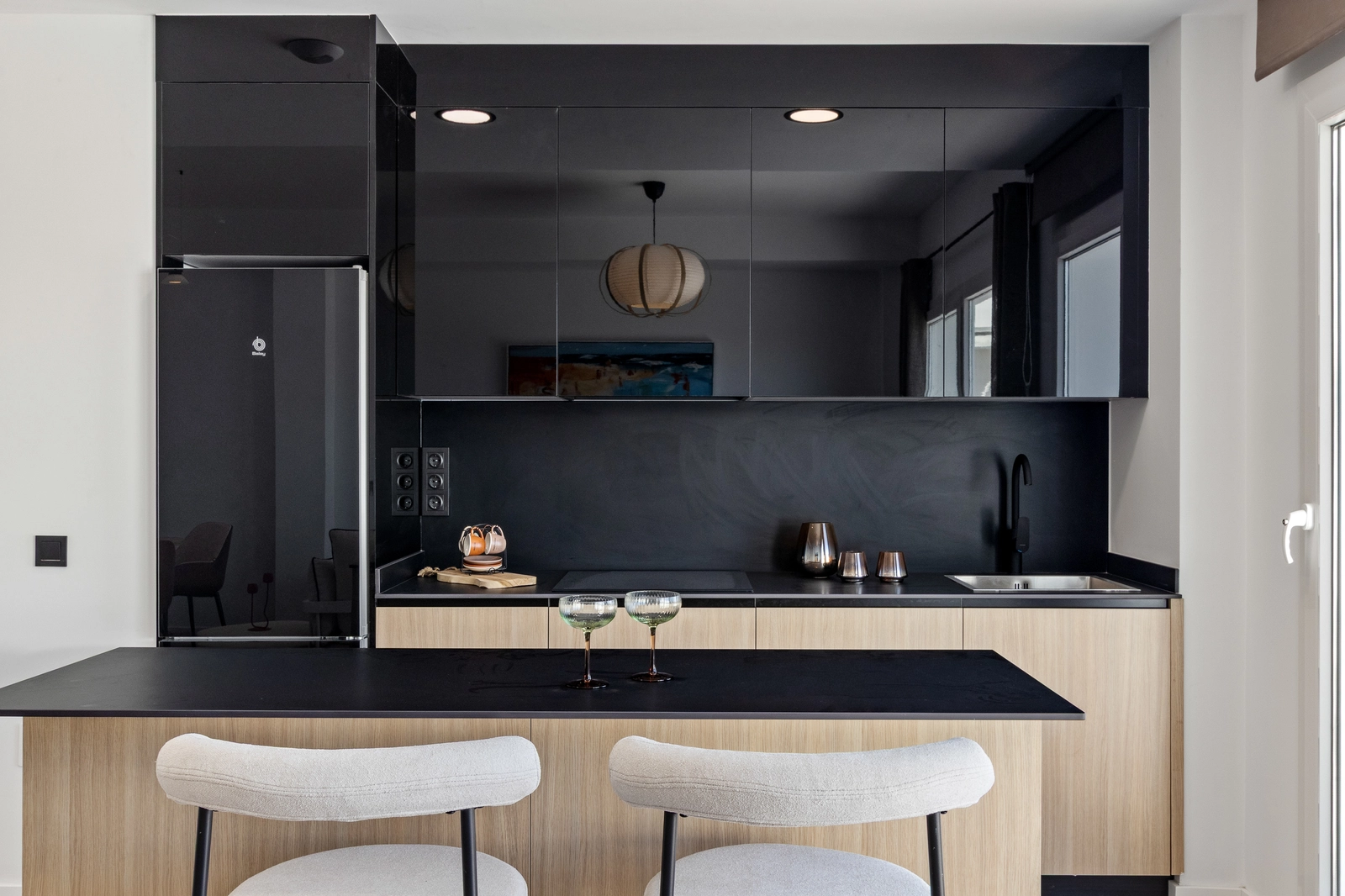 Det slanke, moderne køkken er fuldt udstyret med hårde hvidevarer af høj kvalitet og har en praktisk morgenmadsbar.