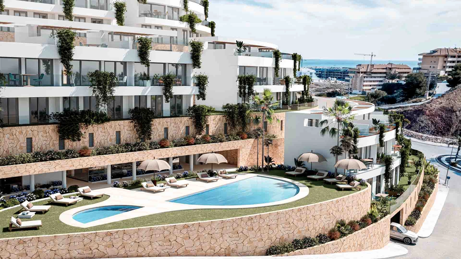 Det elegante fælles swimmingpoolområde, omgivet af natursten og frodig beplantning.