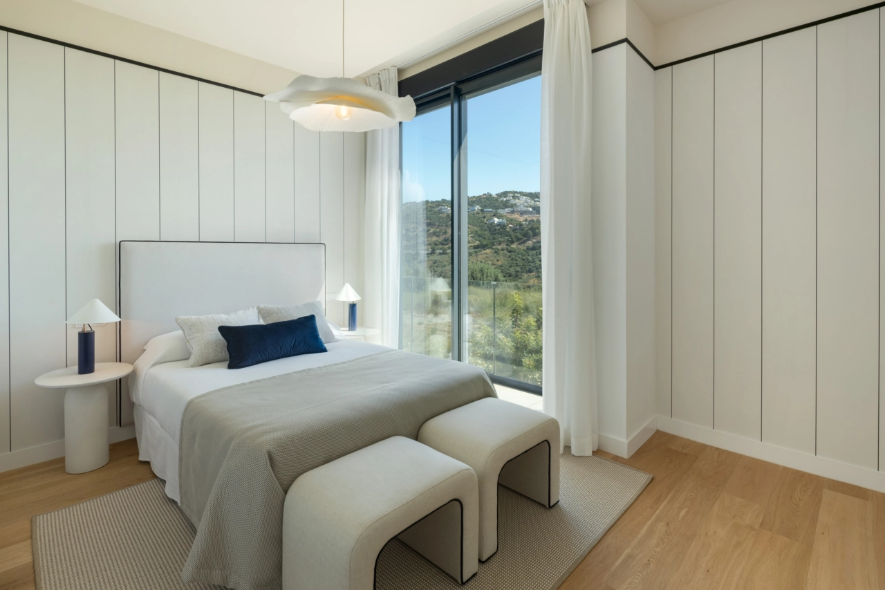 Et komfortabelt gæstesoveværelse med fredfyldt udsigt over det omkringliggende grønne landskab.