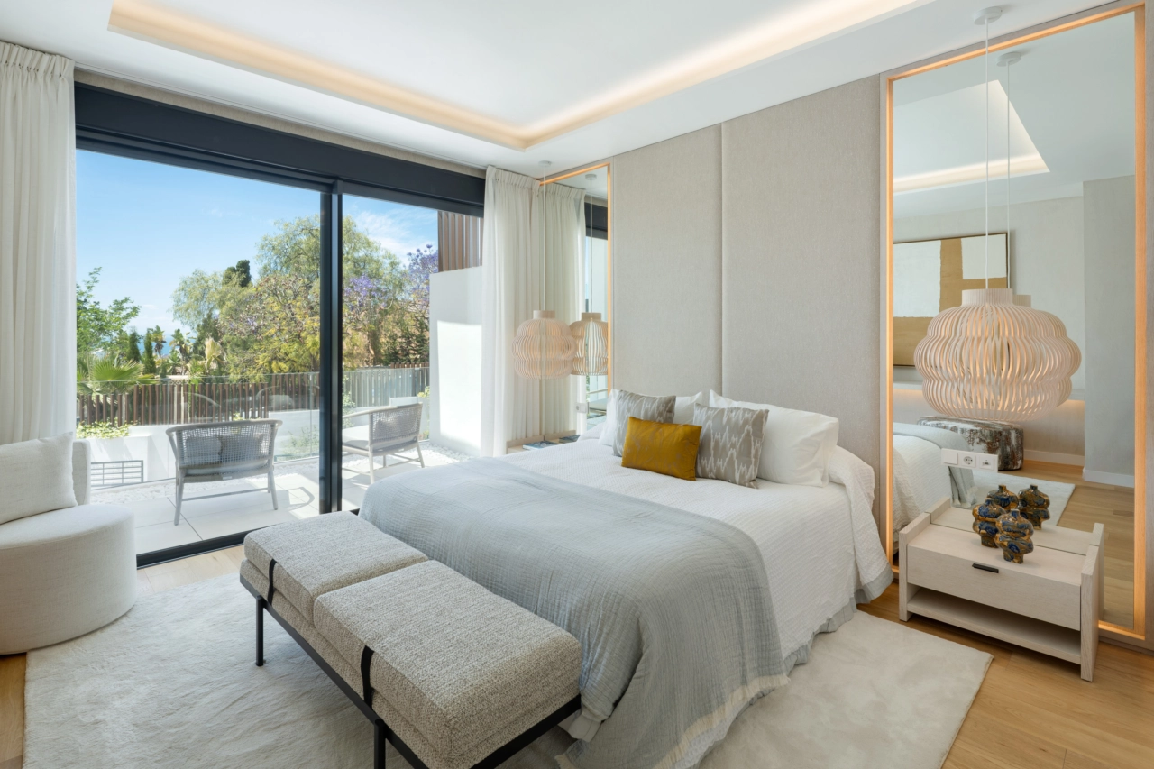 Endnu en udsigt over en smukt indrettet master suite med direkte adgang til en privat terrasse.